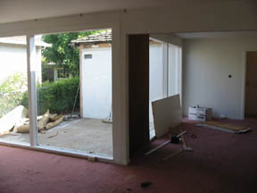 view from inside - roof is gone, carpet is gone, exterior sliding door is gone, curtains removed