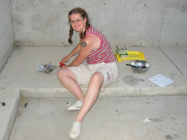 Alison in a bleak parking lot with the camp stove